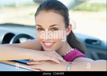 Junge Frau am Autofenster gelehnt Stockfoto