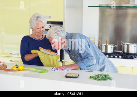 Ältere Mann riecht süßes Essen, während Frau hält es Stockfoto