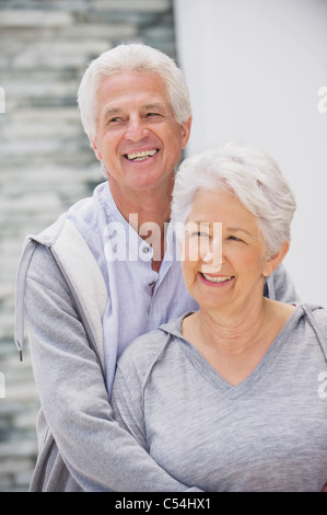 Ältere Mann umarmt seine Frau von hinten Stockfoto