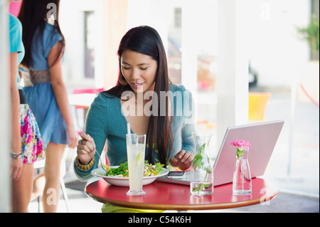 Schöne Frau mit Laptop am Tisch in einem Restaurant Essen Stockfoto