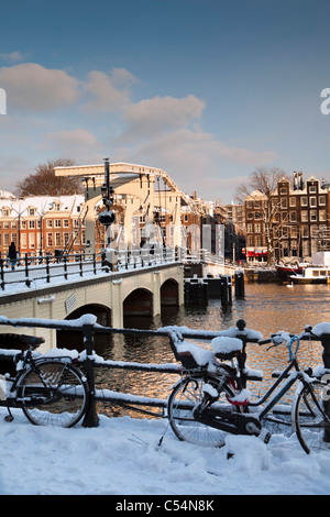 Niederlande, Amsterdam, Häuser 17. Jahrhundert am Fluss Amstel genannt. Hintergrund Skinny Bridge. Winter, Schnee. Stockfoto