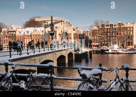 Niederlande, Amsterdam, Häuser 17. Jahrhundert am Fluss Amstel genannt. Hintergrund Skinny Bridge. Winter, Schnee. Stockfoto