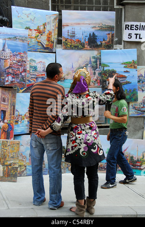 ISTANBUL, TÜRKEI. Ein junges türkisches Paar Gemälde zum Verkauf auf Galipdede Caddesi im Stadtteil Beyoglu zu betrachten. 2011. Stockfoto