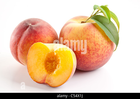 Reife Pfirsichfrucht mit Blättern und Scheiben auf weißem Hintergrund. Stockfoto