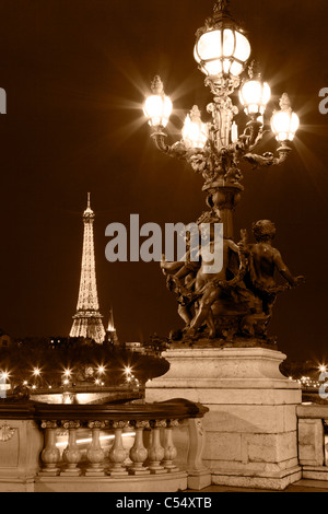 Laterne auf der Brücke Alexander III, vor dem Hintergrund des Eiffelturms bei Nacht. Paris, Frankreich. Stockfoto