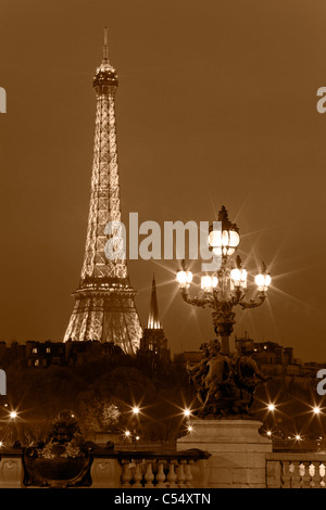 Laterne auf der Brücke Alexander III, vor dem Hintergrund des Eiffelturms bei Nacht. Paris, Frankreich. Stockfoto