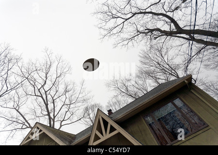 UFO fliegt über ein Haus. Stockfoto