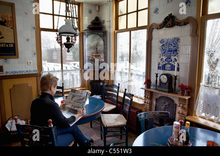 Niederlande, niederländische Eislaufen Kulturhauptstadt. Skating Museum. Mann und Frau, Aufwärmen mit heiße Schokolade im restaurant Stockfoto