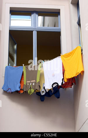 Wäsche zum Trocknen vor ein Fenster gehängt Stockfoto