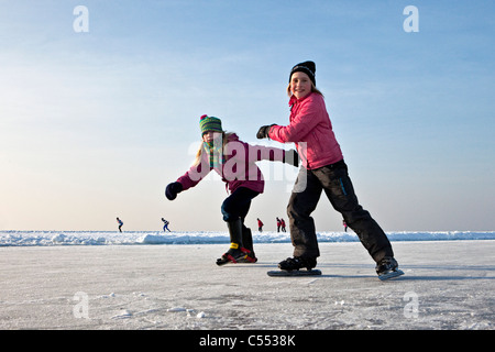 Die Niederlande, Hindeloopen, Kinder Eislaufen auf dem See namens IJsselmeer. Stockfoto