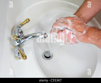 Senior woman waschen Hände in moderne Waschbecken mit Seife und Schaum Einseifen Stockfoto