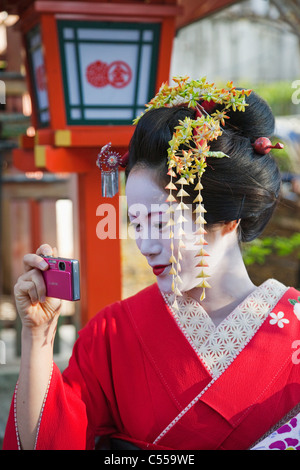 Junge Frau, die Aufnahme eines Bildes mit einem Mobiltelefon, Stadt Kyoto, Kyoto Prefecture, Kinki-Region, Honshu, Japan Stockfoto