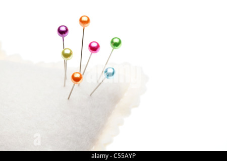 Nähen-Pins und Nadelkissen auf weißem Stockfoto