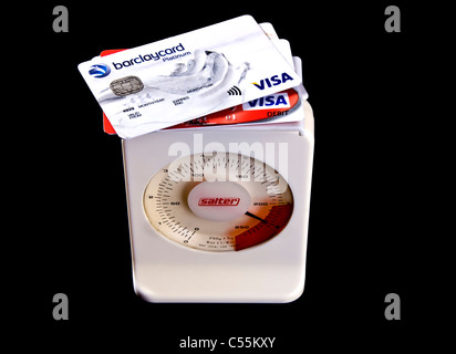 Kreditkarten auf Skalen, schwer mit Schulden gehen in die roten Zahlen. Stockfoto