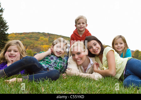 Porträt der Mutter mit fünf Kindern auf dem Rasen liegend Stockfoto