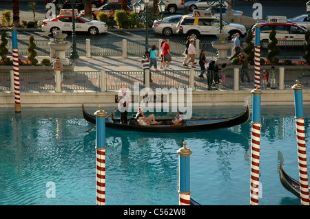 Ein Gondoliere steuert eine Gondel durch den Kanal im Venetian Hotel neben Las Vegas Boulevard in Las Vegas, Nevada. Stockfoto