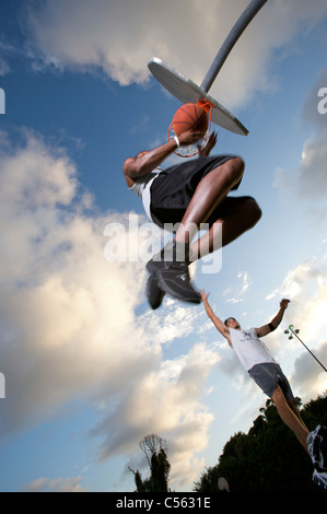 Männchen bei Outdoor-Basketball-Spiel, erzielte aus betrachtet unter Stockfoto