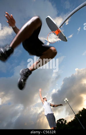 männliche scoring bei Outdoor-Basketball-Spiel, Ansicht von unten Stockfoto