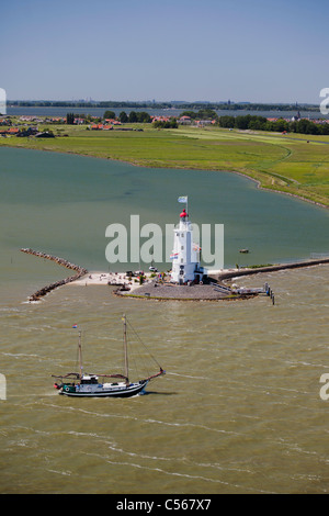 Die Niederlande, Marken, traditionellen Segelboot vorbei Leuchtturm. Lake IJsselmeer genannt. Luft. Stockfoto