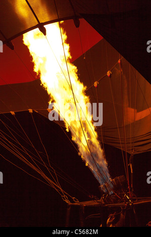 Anheizen der Gasbrenner vor dem Start eines Heißluftballons in der Abenddämmerung in Luxor Stockfoto