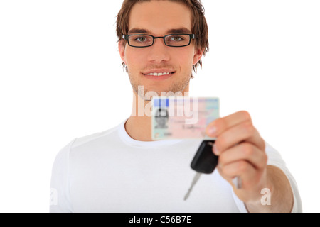 Junger Kerl, der seine Fahrer Führerschein und Auto Schlüssel zeigt. Selektiven Fokus auf Menschen im Hintergrund. Lizenz-Details verschwimmen heraus. Stockfoto