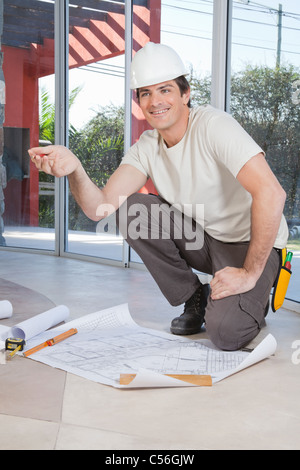 Junge Bauarbeiter zufrieden mit Bauplan Stockfoto