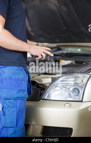 Detail der ein Mechaniker betrachten Arbeitsauftrag auf digital-Tablette Stockfoto