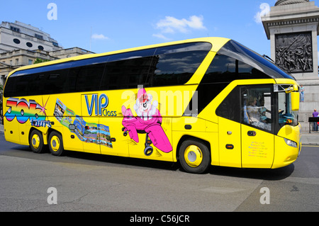 Grafische Gestaltung auf der Seite des gelben deutschen Sightseeing-Bus Bus vorbei Nelsons Column Blue Sky Sommertag in Trafalgar Square London England Großbritannien Stockfoto