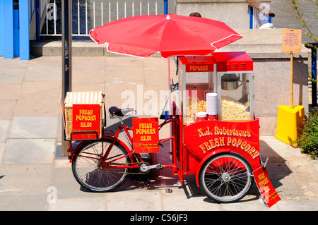 Rot Sonnenschirm über frisches Popcorn Verkäufer Dreirad montiert Maschine laufendes Geschäft für Besucher der Southbank Centre neben Themse London UK