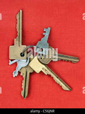 alte Schlüssel von der Tür isoliert auf rotem Grund Stockfoto