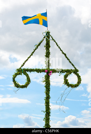 eine traditionelle schwedische Mittsommer-Pol mit einem schwedischen Fähnchen Stockfoto