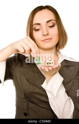 Bild einer jungen Frau, die einen Spielzeug-Baum zu Pflanzen, neben dem Spielzeug-Haus (Fokus auf Haus) Stockfoto