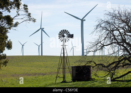 Moderne Windkraftanlagen und einer alten traditionellen Windmühle im Feld in der Nähe von Suisun Stadt am Highway 12, Kalifornien, USA. Stockfoto