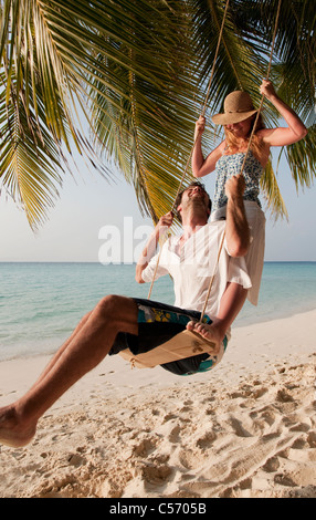 Paar auf Schaukel am Strand spielen Stockfoto