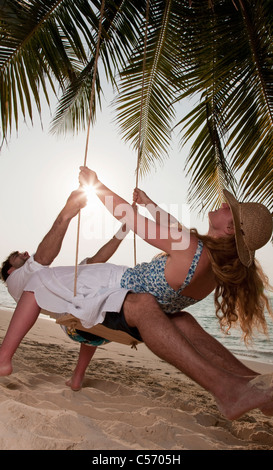 Paar auf Schaukel am Strand spielen Stockfoto