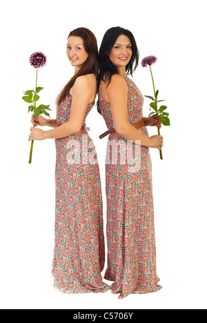Voller Länge von zwei schönen Frauen im gleichen Kleid mit Blumen isoliert auf weißem Hintergrund Stockfoto
