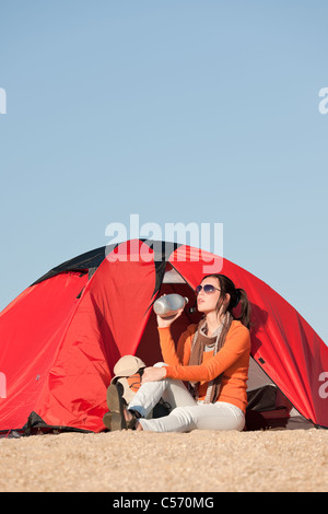 Camping Zelt am Strand blauen Himmel glückliche Frau vorne Stockfoto