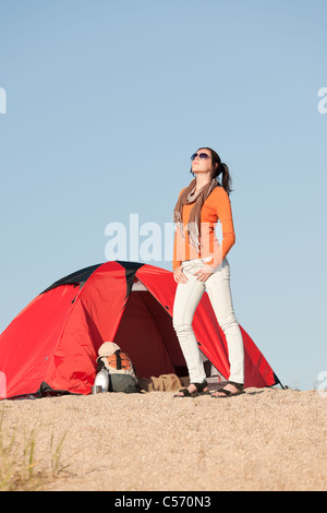 Glückliche Frau im Zelt am Strand blauen Himmel Camping Stockfoto