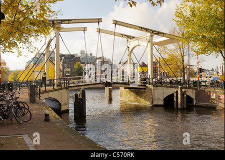 Blick auf traditionelle Drehbrücke an der Herengracht Kreuzung mit dem Fluss Amstel in Amsterdam Stockfoto