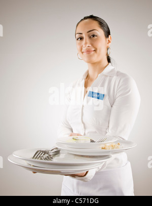 Frau im Namensschild tragen leere Teller Stockfoto