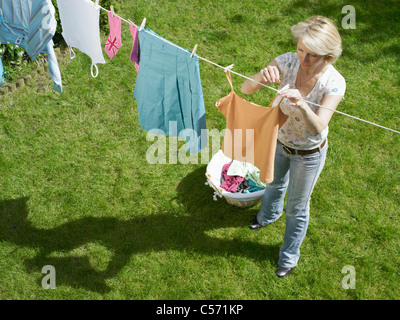 Frau Kleidung auf der Wäscheleine hängen Stockfoto