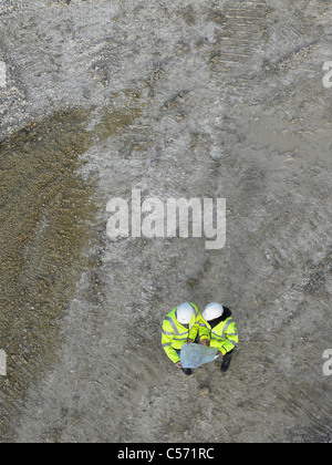 Arbeitnehmer, die Baupläne vor Ort diskutieren Stockfoto