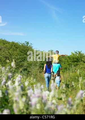 Familie Wandern in Blumenfeld Stockfoto