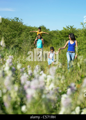 Familie Wandern in Blumenfeld Stockfoto