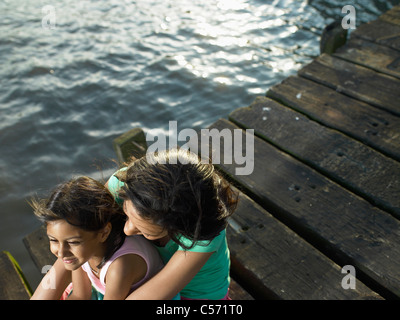 Mutter und Tochter sitzen auf dock Stockfoto