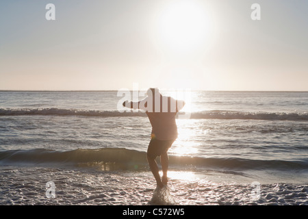 Mann zu Fuß in Wasser am Strand Stockfoto