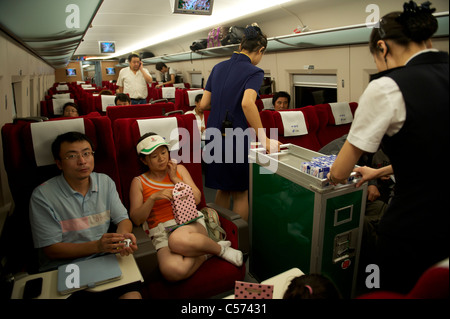 Passagiere sitzen in einem CRH (China Railway High-Speed) Zug Reisen zwischen Shanghai und Peking, in China. 10. Juli 2011 Stockfoto