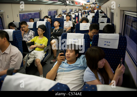 Passagiere sitzen in einem CRH (China Railway High-Speed) Zug Reisen zwischen Shanghai und Peking, in China. 10. Juli 2011 Stockfoto