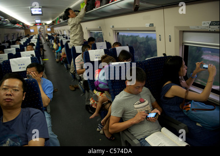 Passagiere sitzen in einem CRH (China Railway High-Speed) Zug Reisen zwischen Shanghai und Peking, in China. 10. Juli 2011 Stockfoto