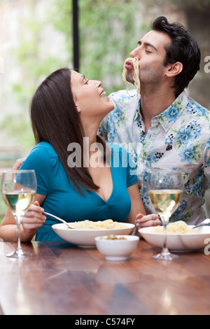 Verspieltes paar gemeinsam am Tisch essen Stockfoto